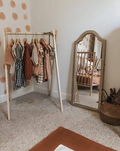 a baby's room with a mirror and clothes rack