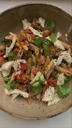 a bowl filled with pasta and vegetables on top of a table