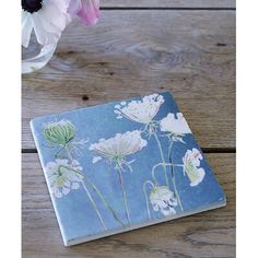 a book sitting on top of a wooden table next to flowers