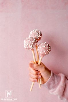 a person holding three lollipops in their hand