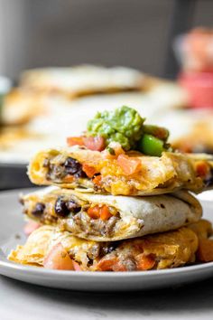 a stack of quesadillas sitting on top of a white plate