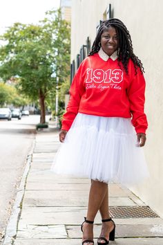 This sweatshirt is perfect for a night out with your line sisters! Paired here with a tutu and our lovely pearl collar for a classy look.You can also rock this sweatshirt with your favorite pair of jeans! The sweatshirt is unisex sized and is available in white, black, and of course red. Made using 50% cotton and 50% polyester pill-resistant air jet yarn. Only the highest quality products are used in creating all of our products. Please utilize the chart to assist with size selection prior to pl Delta Sigma Theta Outfits, Theta Sweatshirt, Greek Paraphernalia, Rocker Outfit, Theta Sorority, Divine Nine, Pearl Collar, Emo Dresses, Greek Apparel