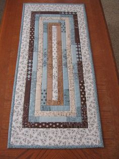 a wooden table with a blue and brown quilt on it