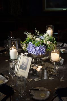 the table is set with candles, flowers and pictures for guests to take photos in