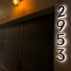 a lit up house number sign on the side of a garage door that reads 2051