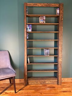 a chair sitting next to a tall wooden book shelf