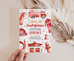 a hand holding up a firefighter's birthday card with watercolor illustrations on it