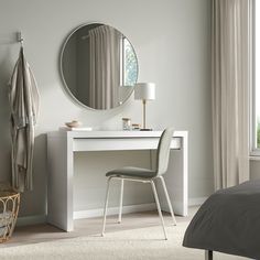 a bedroom with a white desk and mirror