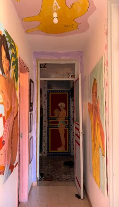 an empty hallway with paintings on the walls and ceiling painted in pink, yellow and orange