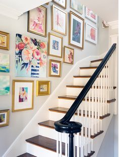 a staircase with pictures on the wall above it