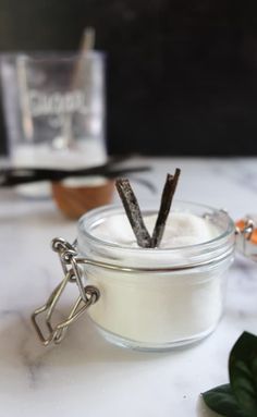 a glass jar filled with some kind of white substance on top of a marble table