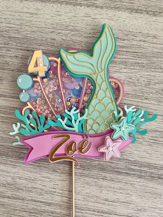 there is a cake topper with a mermaid tail and starfishs on it