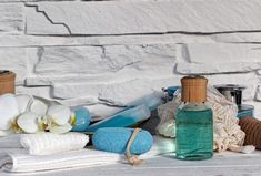 several items are arranged on a table near a brick wall, including towels and soaps