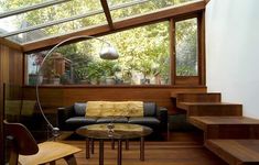 a living room filled with furniture and lots of wooden flooring under a skylight