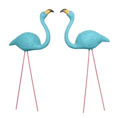 two blue flamingos standing next to each other on red metal legs with gold beaks