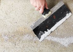 a person using a trowel to remove carpet from the floor