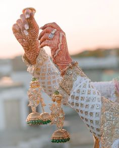 a close up of a person wearing jewelry and holding something in their hand with both hands