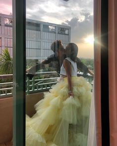 a man and woman are kissing on the balcony