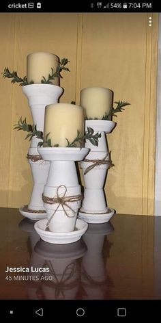 four white candles sitting on top of each other