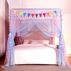 a canopy bed with pink and blue curtains on the top, and lights hanging from the ceiling