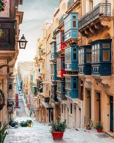 an empty street with lots of windows and balconies on the buildings next to it