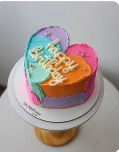 a heart shaped birthday cake sitting on top of a table