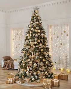 a decorated christmas tree with gold ornaments and presents on the floor in front of it