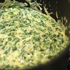 spinach and cheese cooking in a pan on the stove