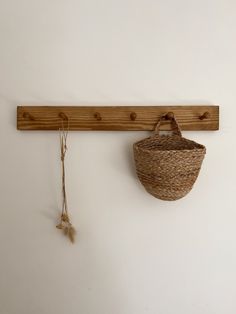 a basket hanging on the wall next to a wooden hook