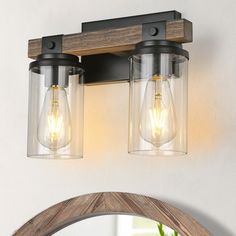 two light fixtures mounted on the wall above a mirror