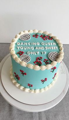 a blue cake with white frosting and red flowers on it