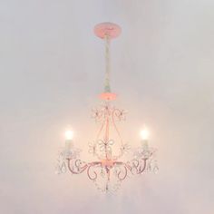 a pink chandelier hanging from the ceiling in a room with white walls and flooring