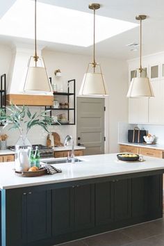 a kitchen with an island and hanging lights