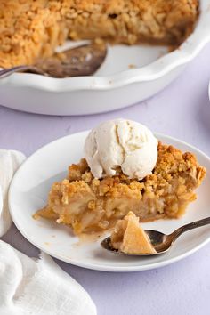 a slice of pie on a plate with a scoop of ice cream next to it