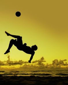 a person jumping into the air to catch a frisbee in front of an orange and yellow sky