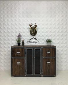 the sideboard is made out of wood and has two drawers on each side, with a deer head above it