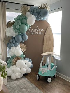 a car is parked in front of a balloon arch