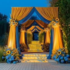 an outdoor wedding ceremony with sunflowers and blue drapes on the side walk