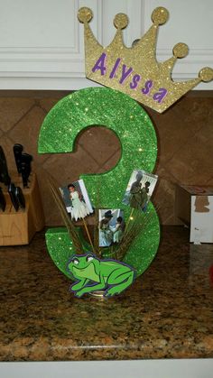 there is a green number with pictures on it and a crown above the number three