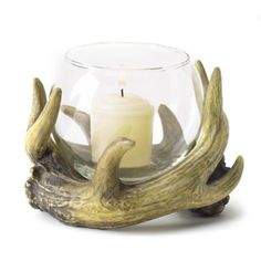 a candle that is inside of a glass bowl with antlers on it and a candle in the middle