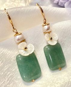 Add a touch of elegance to your ensemble with our Natural Jade Dangle & Drop Earrings. Featuring beautiful green jade, delicate floral designs, and the timeless charm of pearls, these earrings are a perfect blend of sophistication and style. Key Features: - Natural Jade: Each earring features a genuine jade stone, known for its rich green hue and natural beauty, ensuring a unique look with each pair. - Elegant Floral Design: The floral design, accented with pearls, adds a touch of elegance and f Green Pearl Earrings, Stone Drop Earrings, Flowers Earrings, Gem Earrings, Jade Earrings, Diy Crystals, Earrings Elegant, Rich Green, Natural Jade