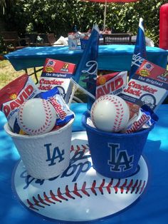 two buckets filled with balls sitting on top of a blue tarp covered table