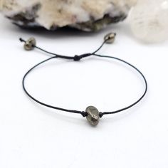 This minimal Pyrite bracelet is made with black waxed cotton cord and sliding knot that allows you to slide it over your hand and tighten it to your desired fit ◇ Meaning Pyrite is a powerful protection stone. It stimulates the intellect and enhances memory, helping to recall relevant information. Pyrite assists one in seeing behind facades, promoting an understanding of that which lies beneath words and actions. ◇ Suggestions Everyone responds differently to crystals. What works for one may not Everyday Braided Bracelet With Sliding Knot, Adjustable Waxed Cord Bracelets For Everyday, Adjustable Waxed Cord Jewelry For Everyday, Adjustable Hand Wrapped Minimalist Bracelets, Minimalist Adjustable Hand Wrapped Bracelets, Minimalist Hand-wrapped Adjustable Bracelets, Spiritual Friendship Bracelet With Sliding Knot For Everyday, Spiritual Friendship Bracelets With Sliding Knot For Everyday, Minimalist Jewelry With Adjustable Waxed Cord