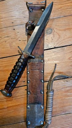 a knife and sheath sitting on top of a wooden table