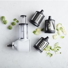 four different types of vegetable choppers on a white surface with some vegetables scattered around them