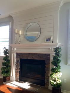 a living room with a fire place and a mirror on the wall above it's mantle