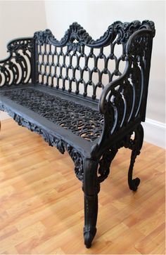 a black bench sitting on top of a hard wood floor