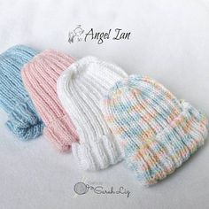 three knitted hats sitting next to each other on top of a white sheet with the words angel inn written above it