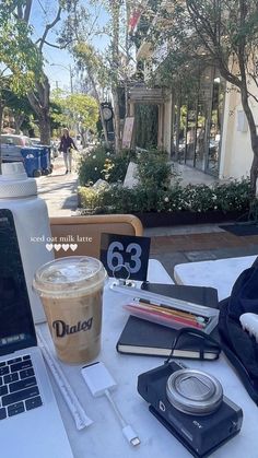 a laptop computer sitting on top of a white table next to a cup of coffee