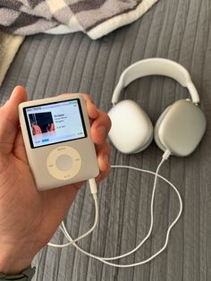 a person is holding an ipod and headphones